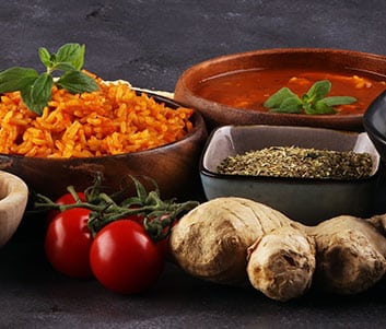 Assortiment Épices, Gingembre et Riz pour Cuisine Savoureuse Gros plan sur des ingrédients de cuisine : riz rouge, soupe, tomates cerises, gingembre, et herbes séchées, suggérant une cuisine épicée ou méditerranéenne.